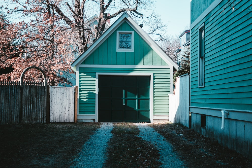A garage in the backyard of a house.