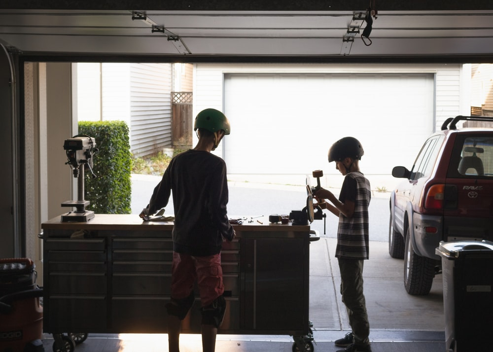 Two young boys fixing something in the garage