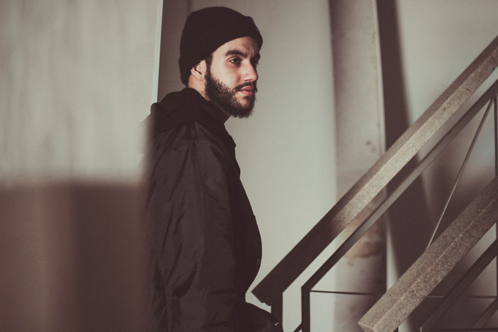 A suspicious-looking man standing near a staircase