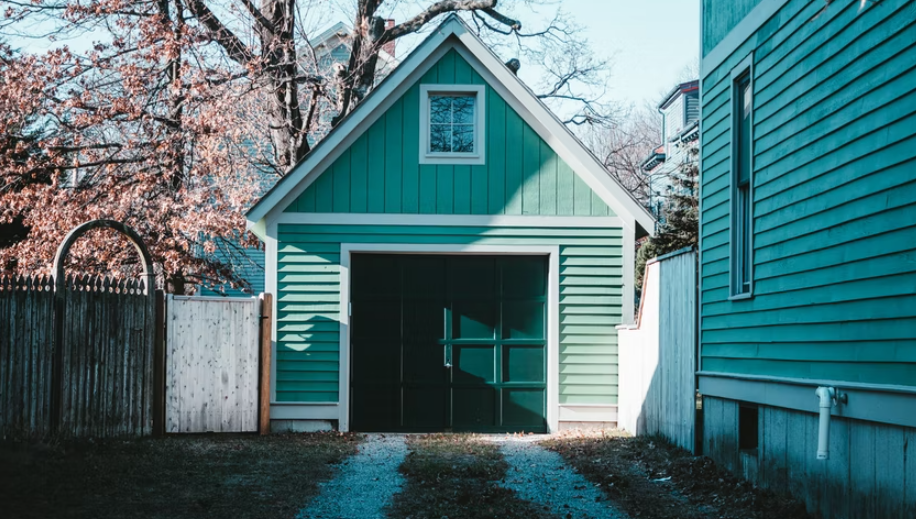 green garage with a dark green door. 