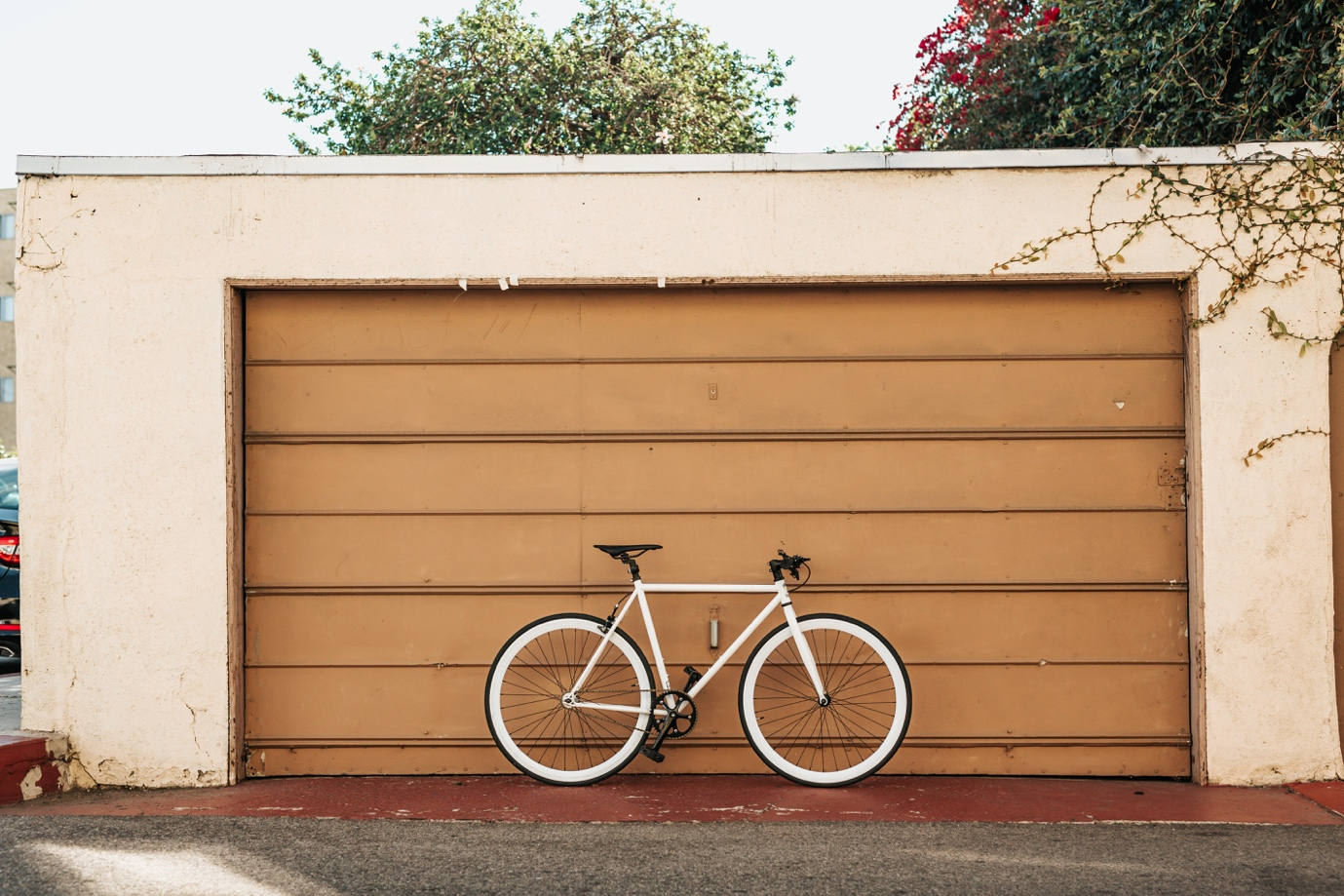 A bicycle parked outside a garage door