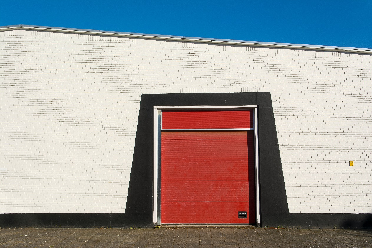 Red garage door serviced to increase the lifespan of garage door cables