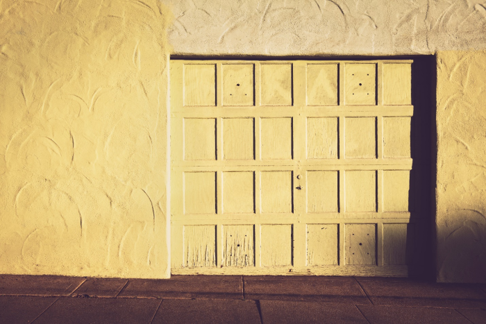 An old white garage in need of garage door lubrication