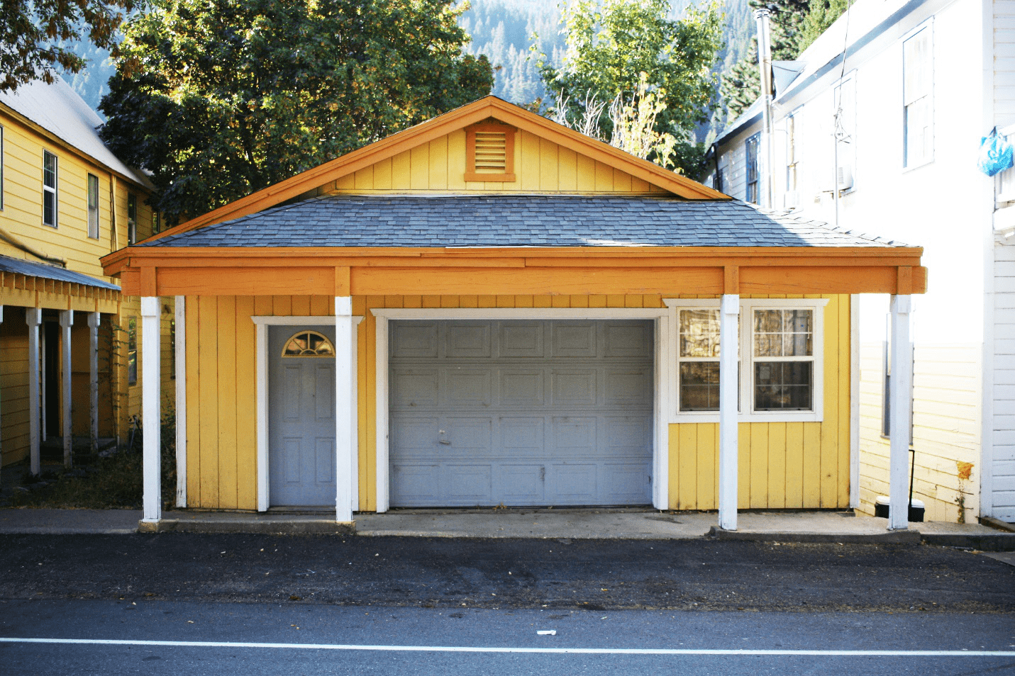 a yellow house with a white garage door