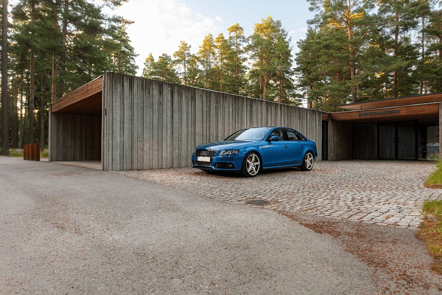 a blue car driving out of a garage door